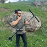 تصویر فردی در طبیعت که یک دستگاه فلزیاب اسکنر Hector Pro محصولی از شرکت xsense را در دست دارد.